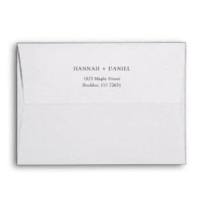 Plain black and white 5" x 7" wedding invitation envelope with names and return address on back flap